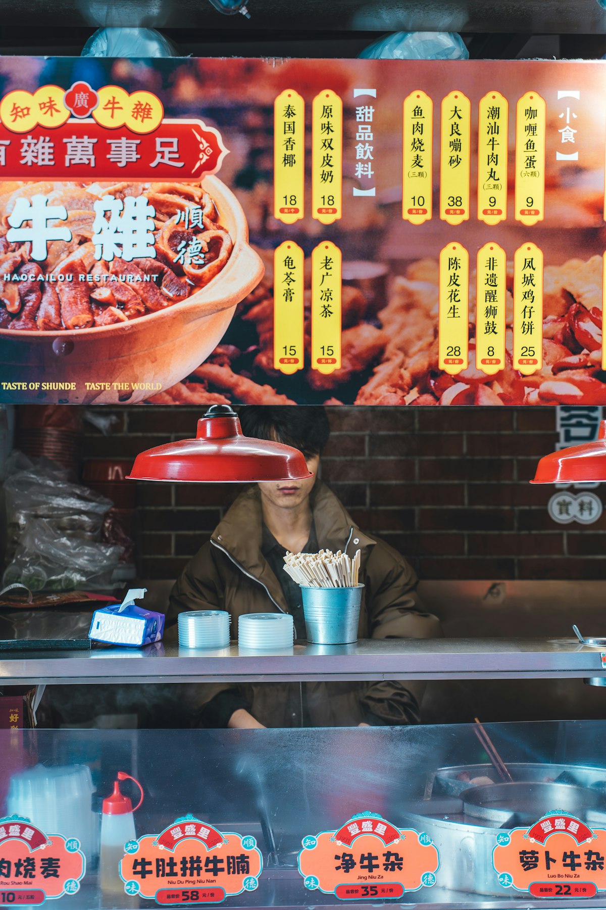 A Shanghai food stall with its menu and vendor at night