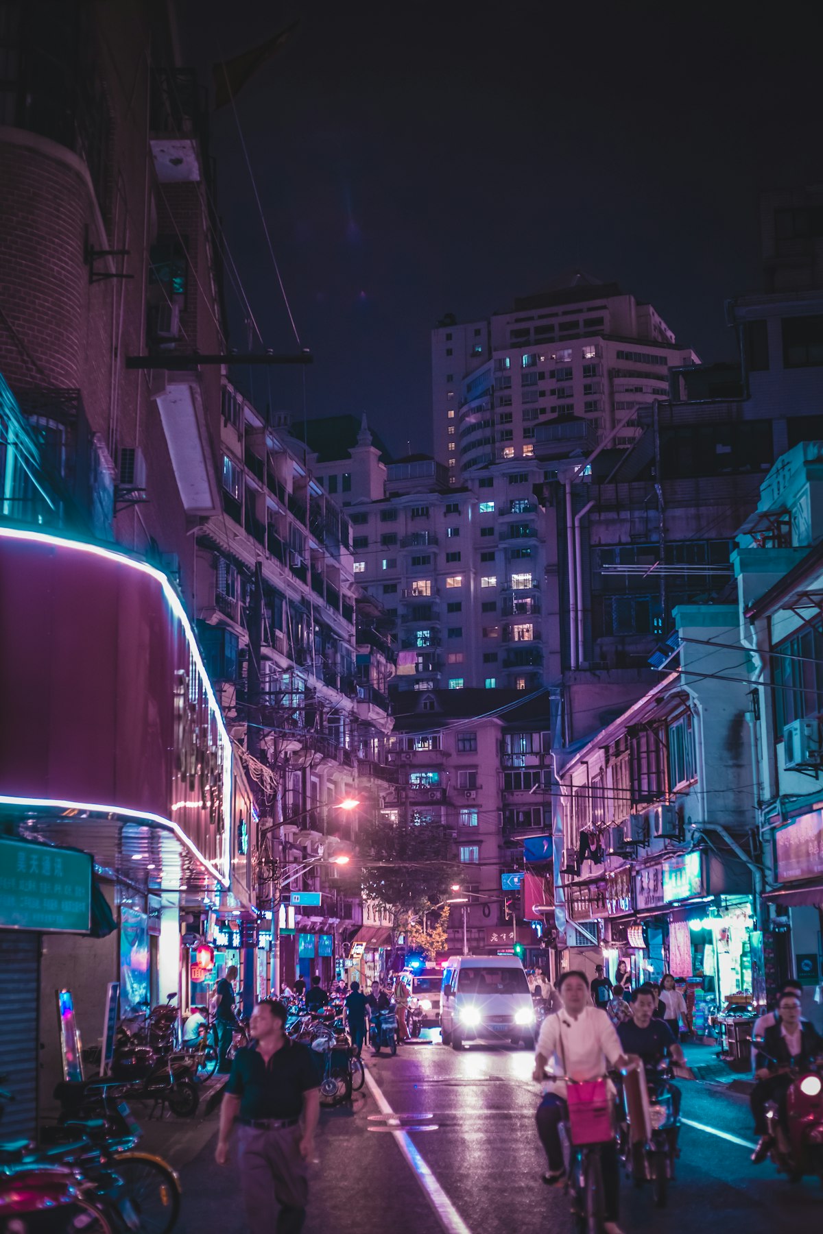 People walking through a neon-lit Shanghai street at night